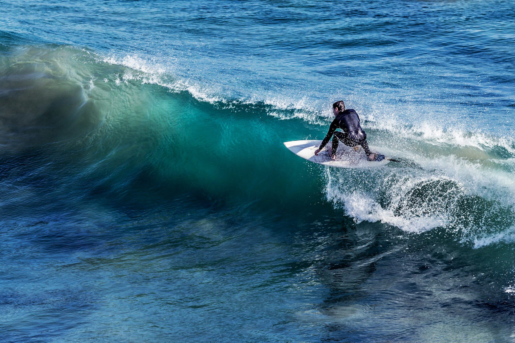 Surfer riding a crystal blue wave